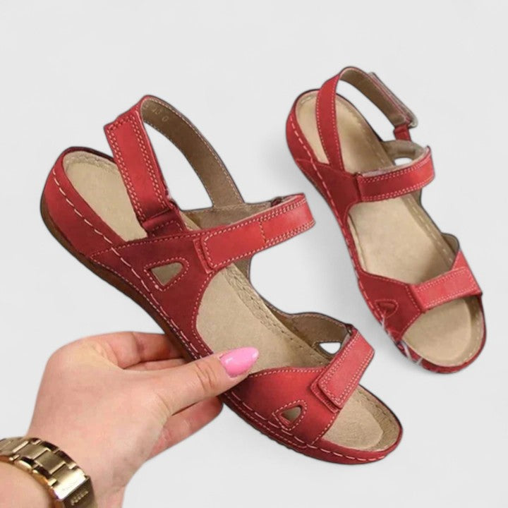 A woman walking through town in tan flat comfort sandals, relaxed and at ease.