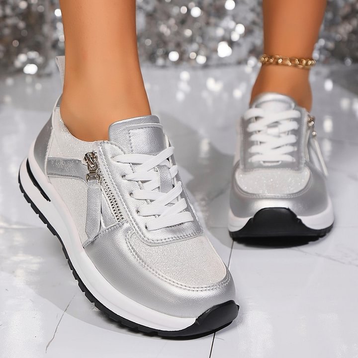 A woman in silver orthopaedic sneakers with a handy side zip.