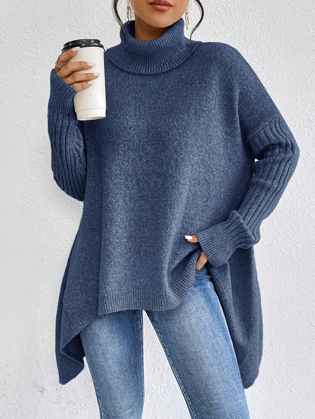 A woman wearing a stand-collar sweater with a chic asymmetric drape, warm and polished.