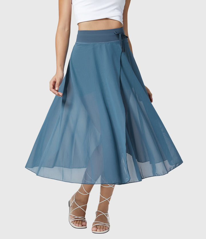 A woman in an elegant high-waisted flowing skirt, styled for a versatile day-to-evening look.