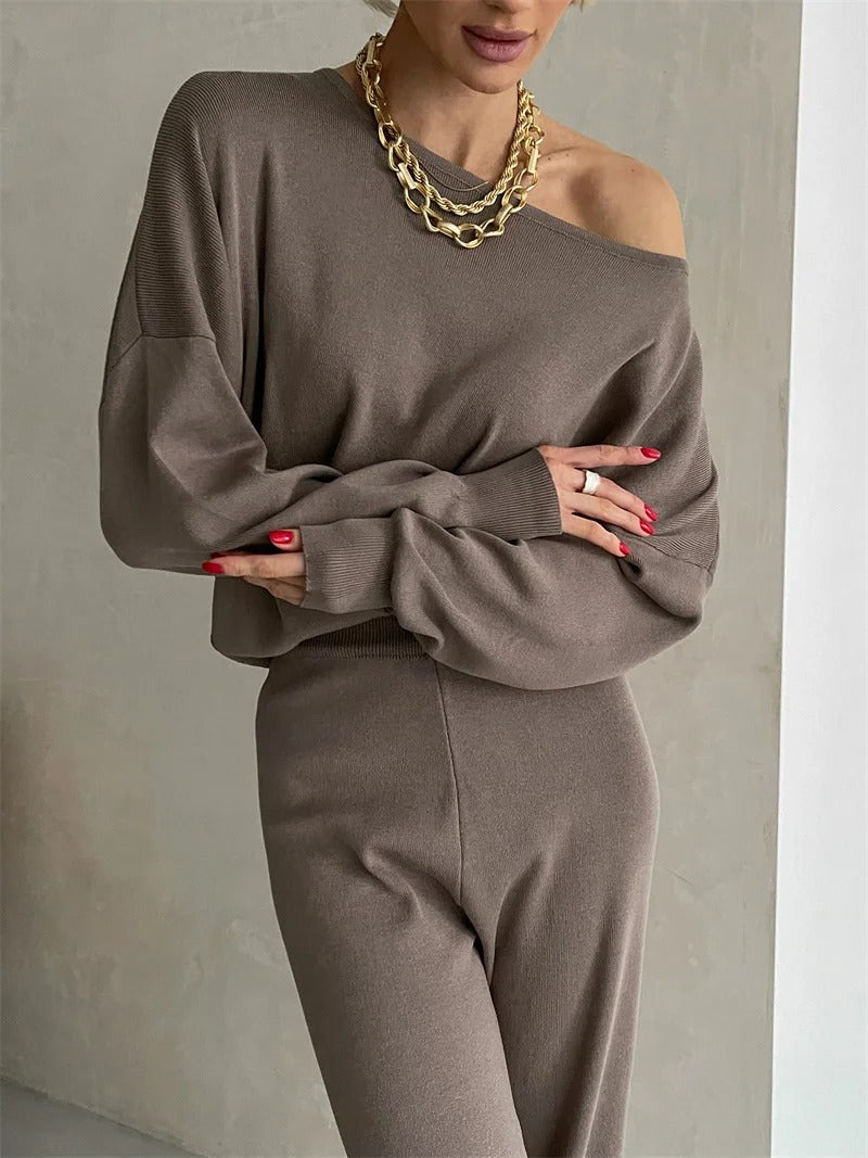 A woman wearing an off-shoulder draped top with wide-leg pants