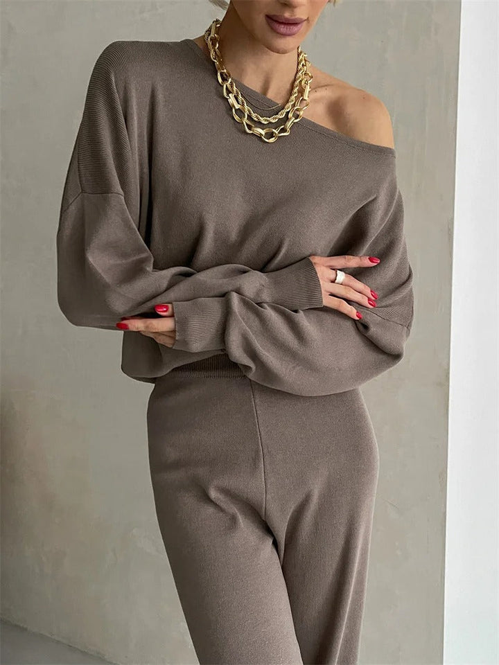 A woman wearing an off-shoulder draped top with wide-leg pants