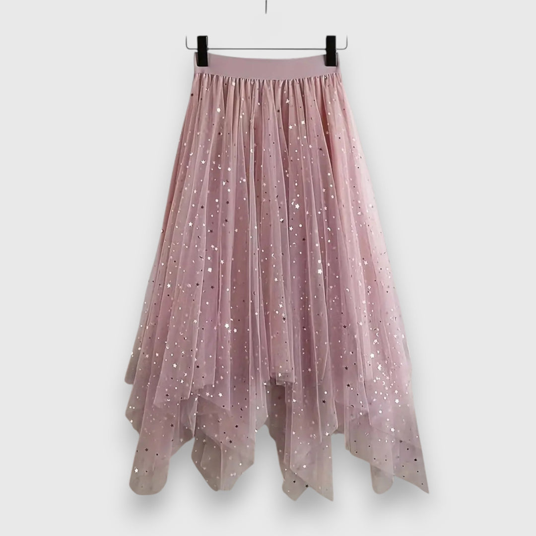 A woman wearing a high-waisted shimmering skirt with a soft ruffled hem.