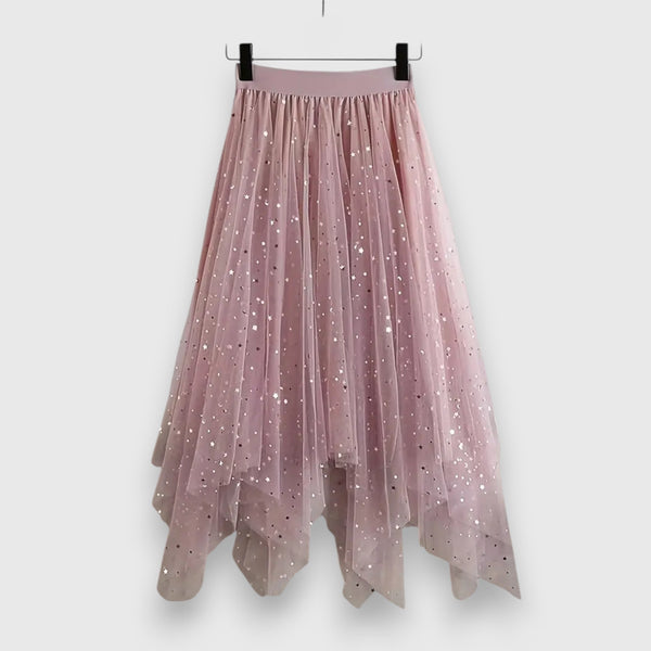 A woman wearing a high-waisted shimmering skirt with a soft ruffled hem.