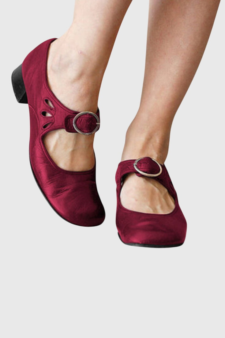 A woman wearing low heel Mary Janes with an adjustable strap, dressed for work.