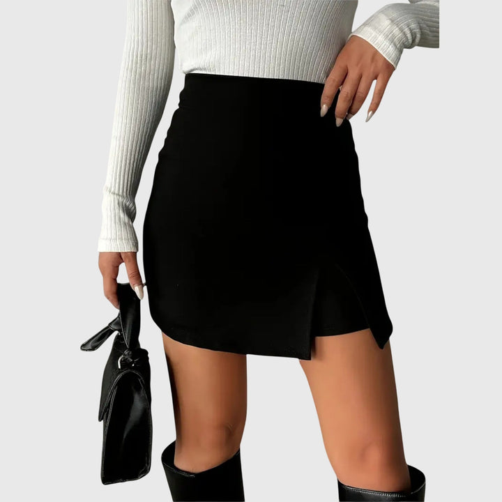 A woman wearing a sleek high-waisted black mini skirt with a front slit.