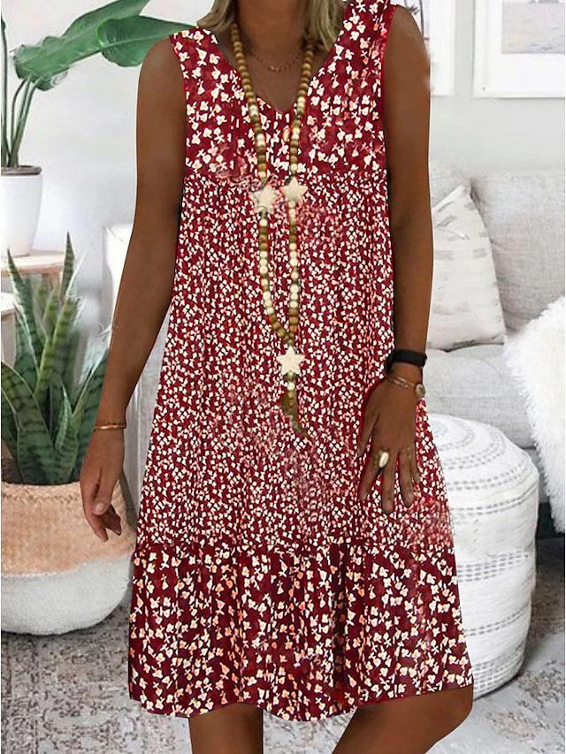A woman wearing the Wendy sleeveless V-neck floral dress on a sunny day outdoors.