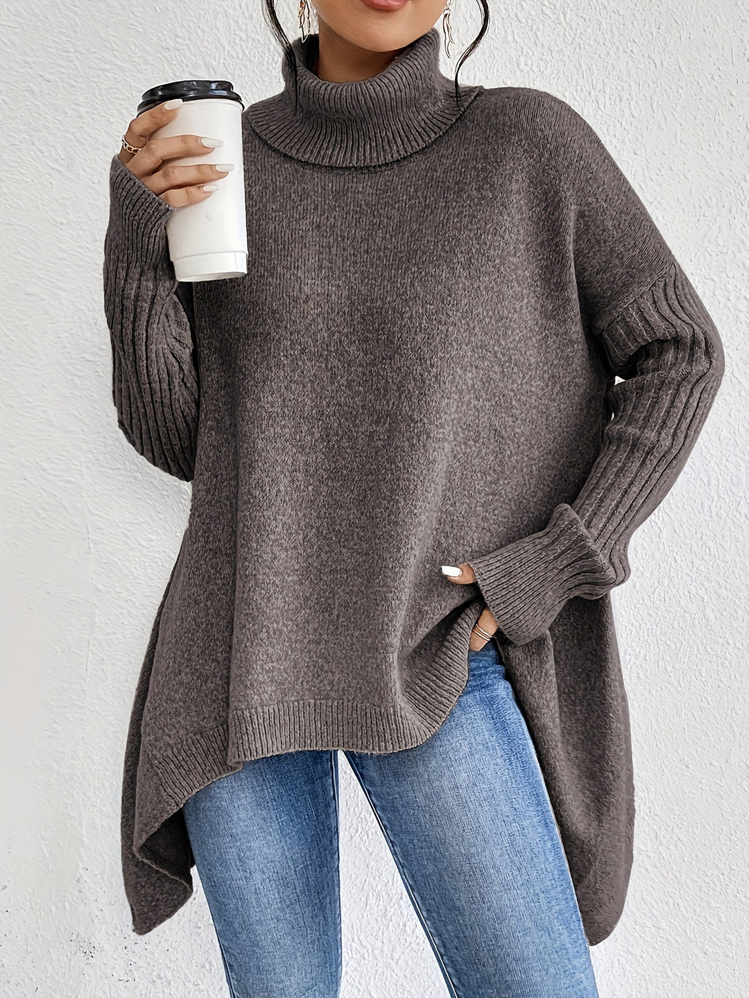 A woman wearing a stand-collar sweater with a chic asymmetric drape, warm and polished.