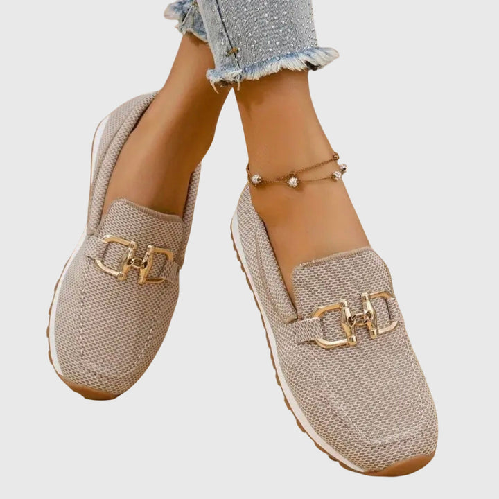A woman in smart-casual orthopaedic loafer sneakers with a subtle golden detail.