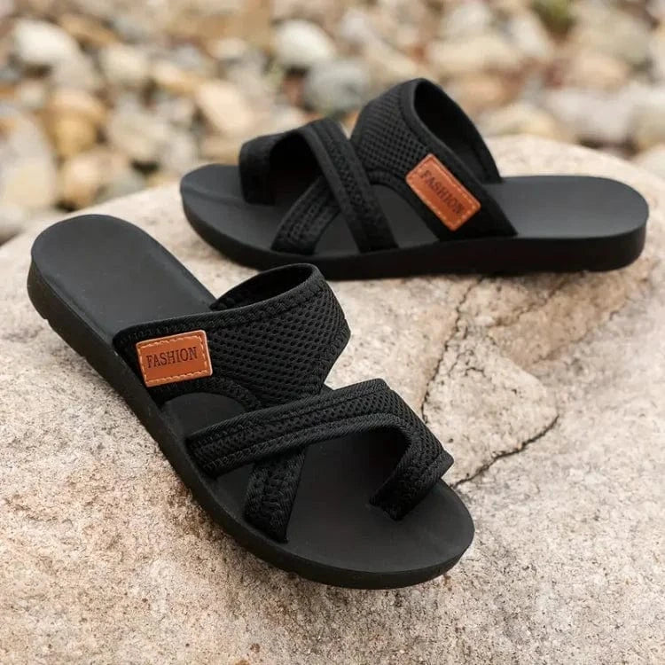 A woman on a summer walk wearing red comfort sandals with a broad, cushioned footbed.