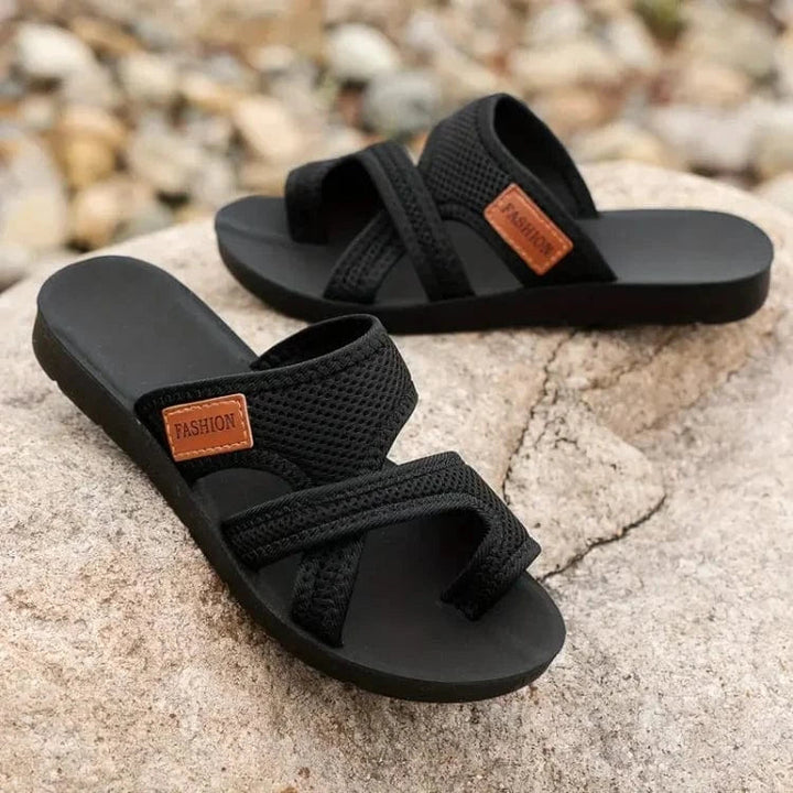 A woman on a summer walk wearing red comfort sandals with a broad, cushioned footbed.