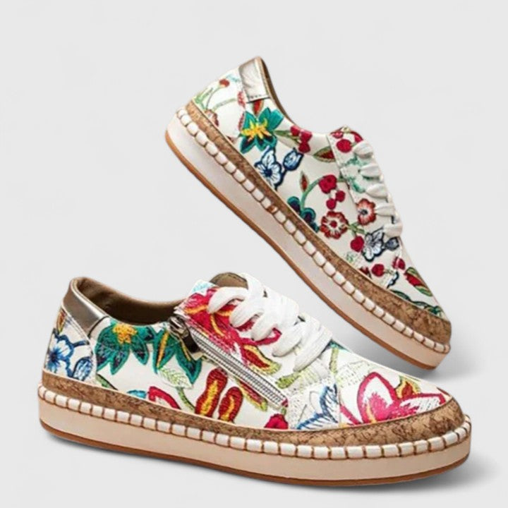 A woman wearing floral lace-up orthopaedic sneakers with a side zip and platform sole.