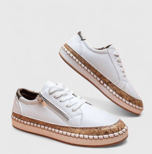 A woman wearing floral lace-up orthopaedic sneakers with a side zip and platform sole.