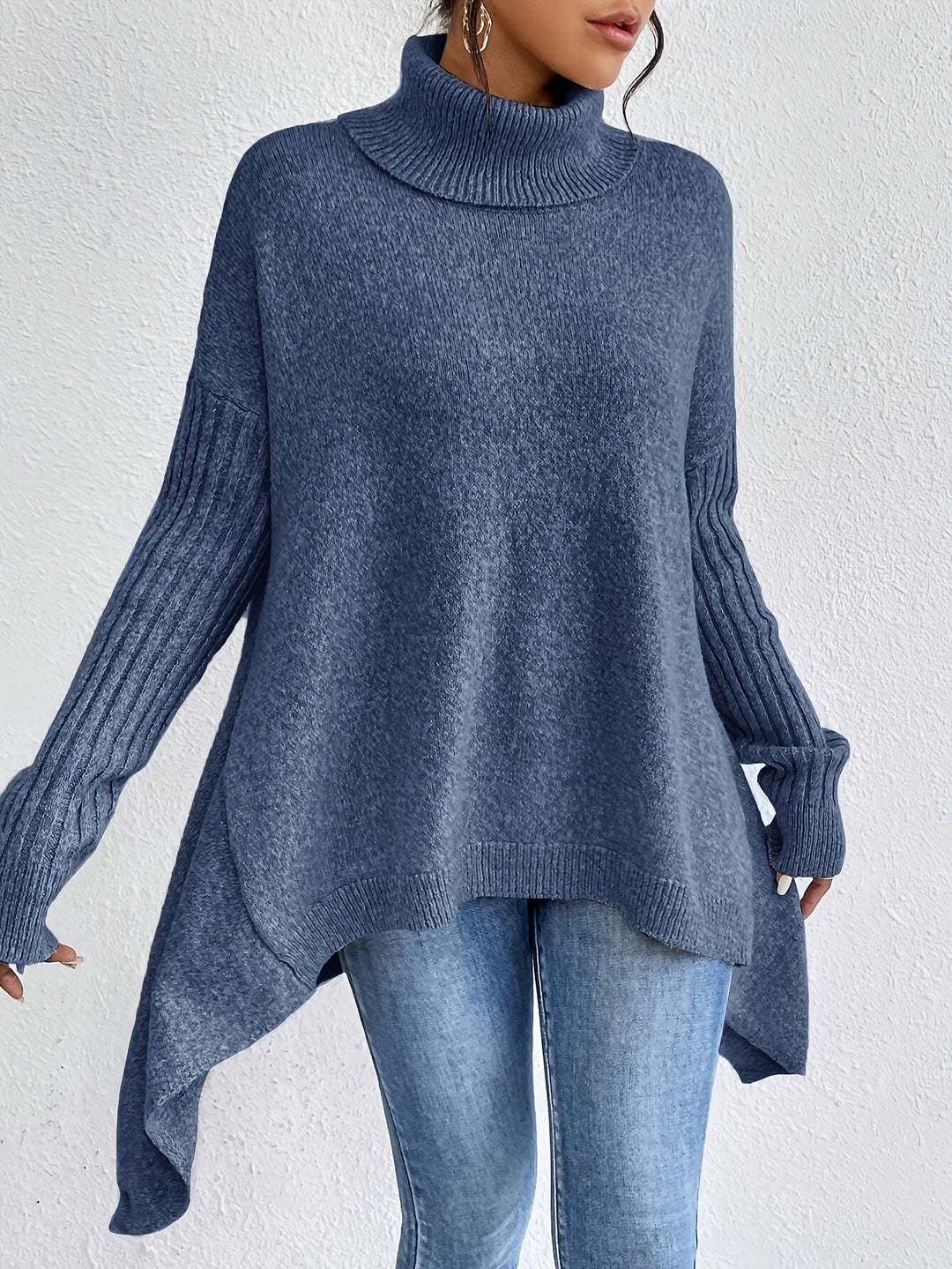 A woman wearing a stand-collar sweater with a chic asymmetric drape, warm and polished.