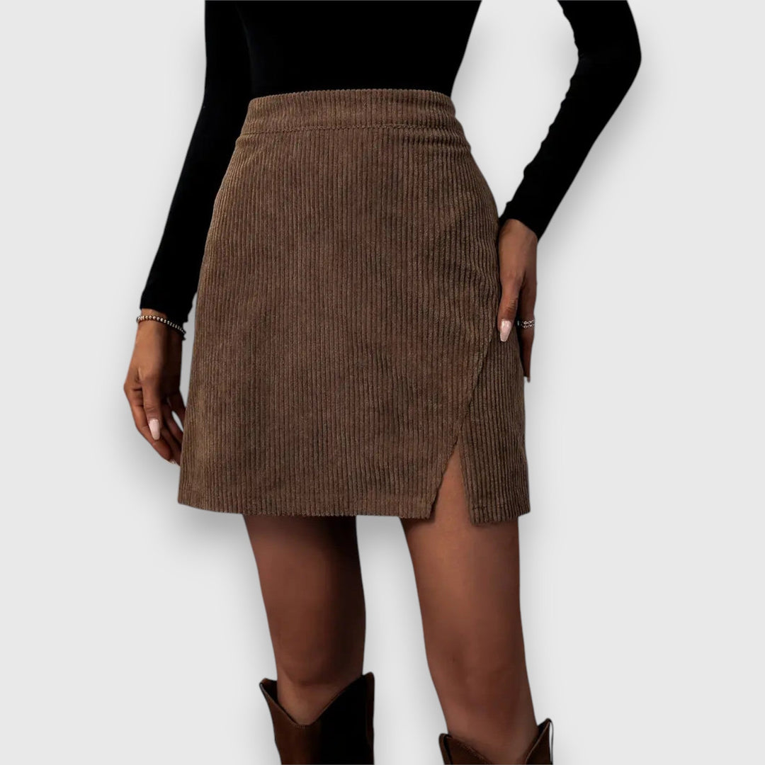 A woman in a textured ribbed skirt with a front slit, styled with a sweater for a relaxed fall look.