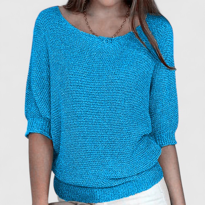 A woman wearing a soft purple sweater with a wide neckline and gently shaped fit.