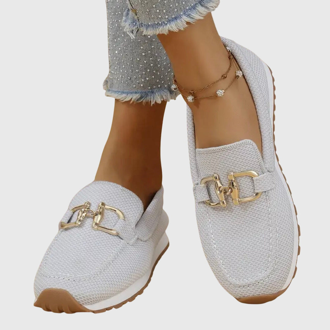 A woman in smart-casual orthopaedic loafer sneakers with a subtle golden detail.