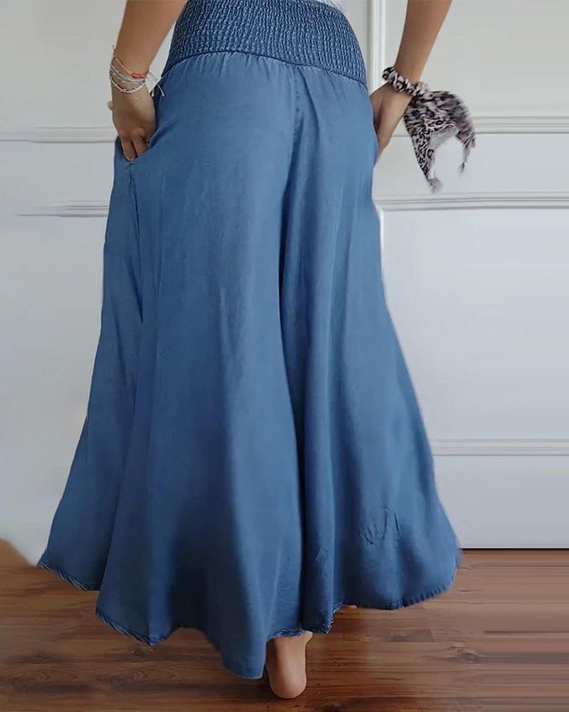 Woman wearing high-waist wide-leg pants with a tucked-in blouse, mid-stride.