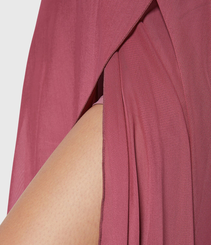 A woman in an elegant high-waisted flowing skirt, styled for a versatile day-to-evening look.