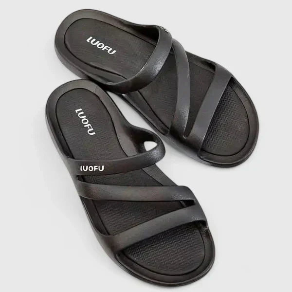 A woman walking confidently outdoors in supportive, cushioned orthopaedic sandals.