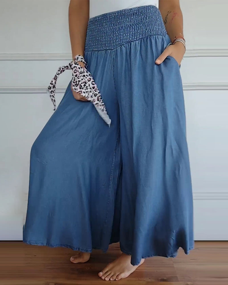 Woman wearing high-waist wide-leg pants with a tucked-in blouse, mid-stride.