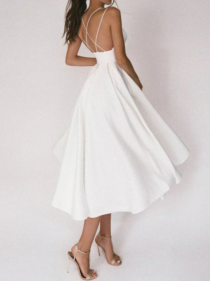 Woman at a summer celebration wearing the Beth minimalist maxi dress with fine double straps and a floating skirt.