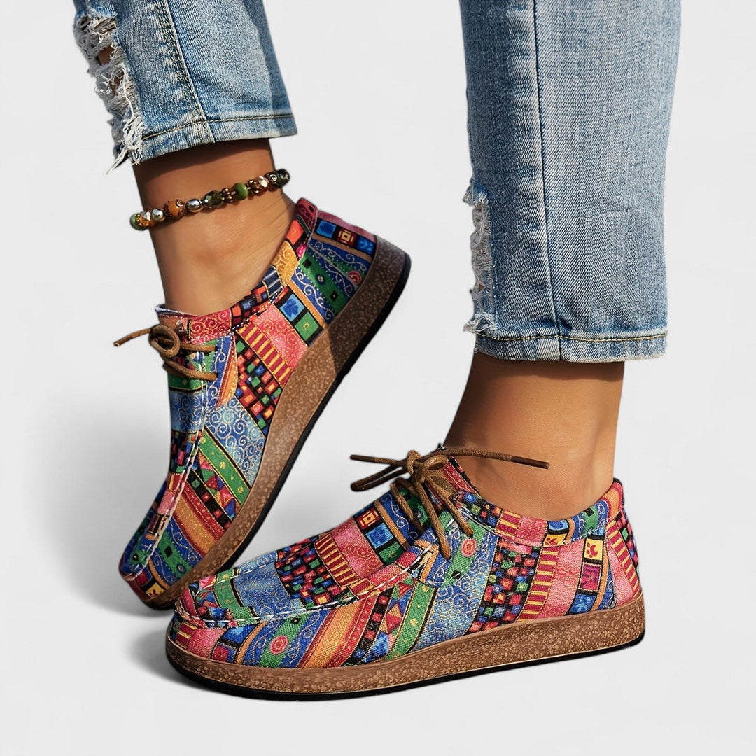 A woman wearing green boho-patterned lightweight sneakers on a walk in town.
