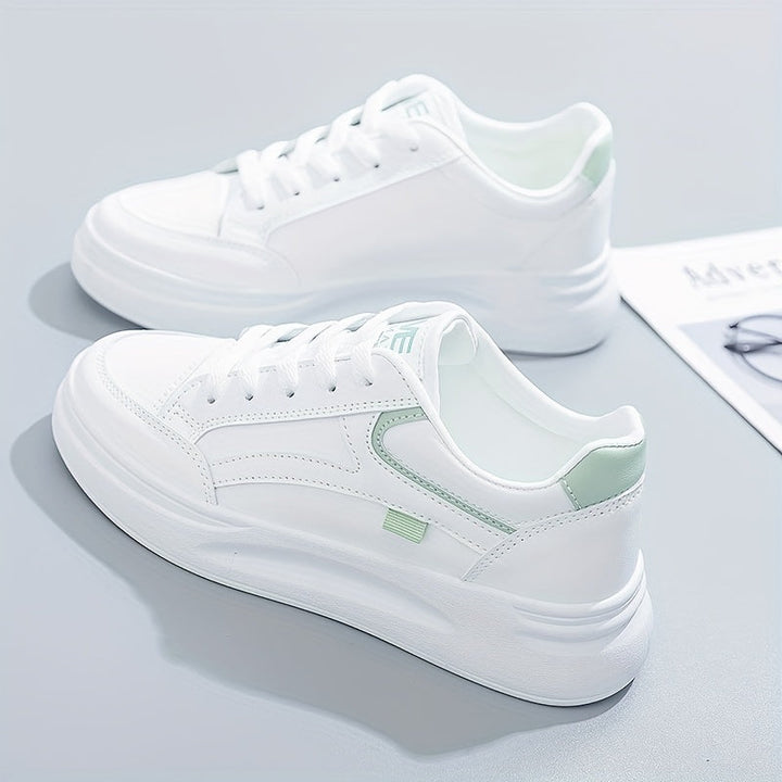 A woman in crisp white light comfort sneakers paired with jeans.