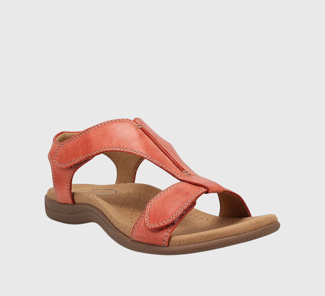 A woman wearing T-strap comfort sandals with a summer dress, looking relaxed and elegant.