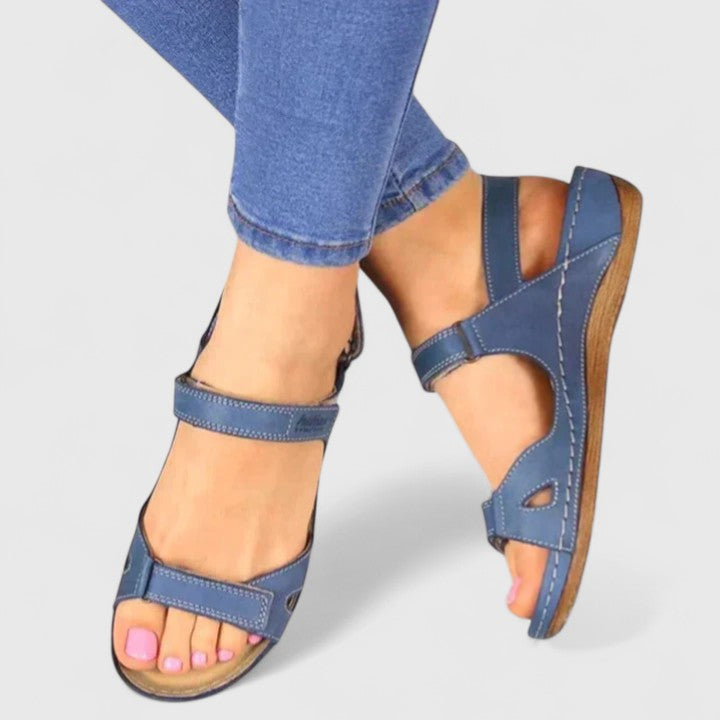 A woman walking through town in tan flat comfort sandals, relaxed and at ease.