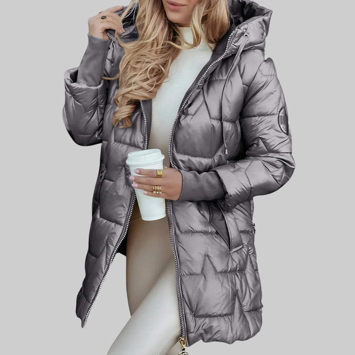 A woman wearing a hooded fall coat in a timeless tone, sheltered from the wind.
