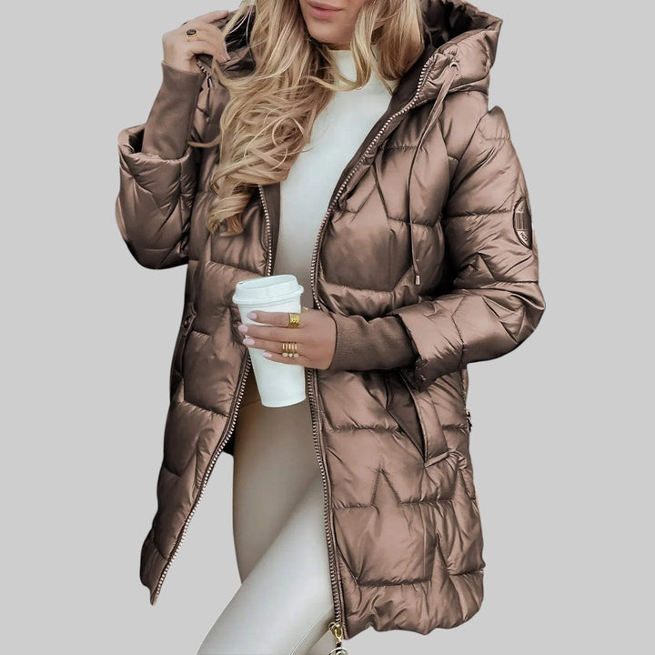 A woman wearing a hooded fall coat in a timeless tone, sheltered from the wind.