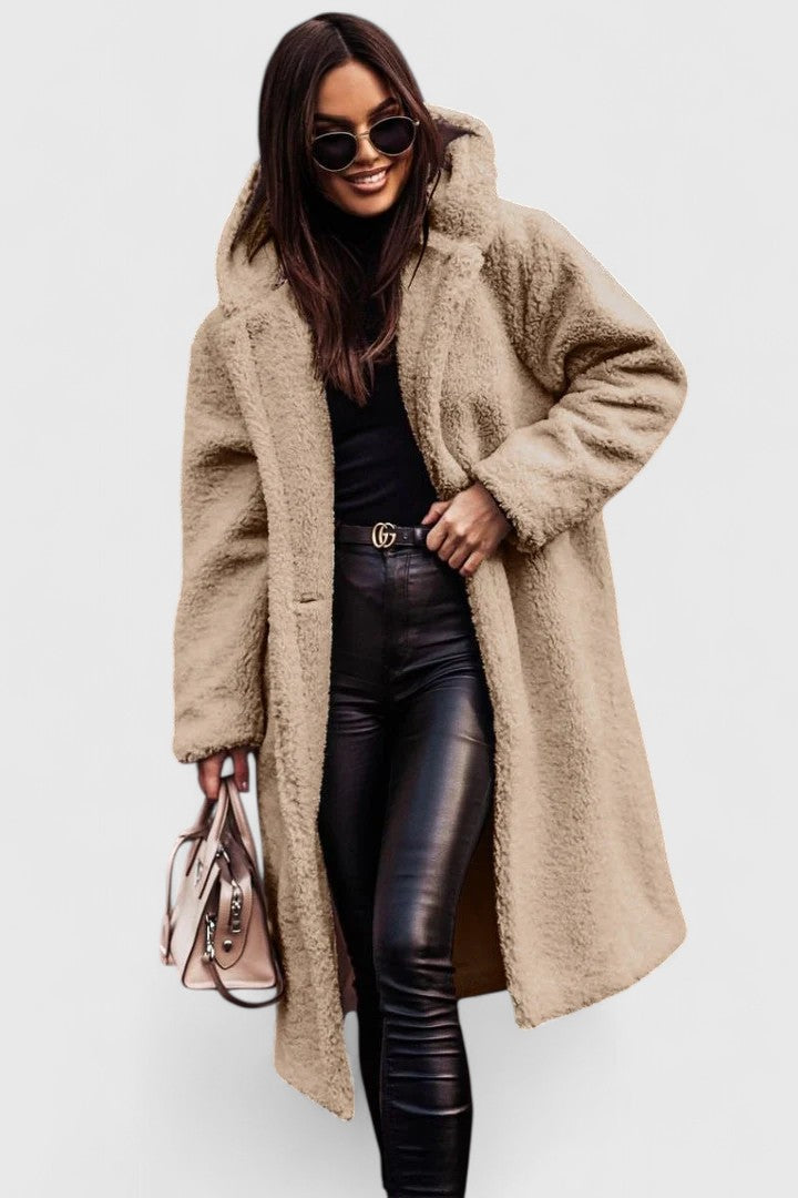 A woman wearing a long, softly textured hooded winter coat with an open front