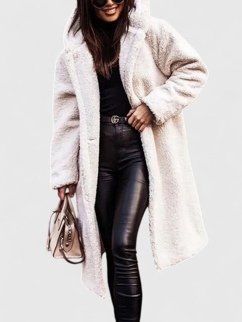 A woman wearing a long, softly textured hooded winter coat with an open front