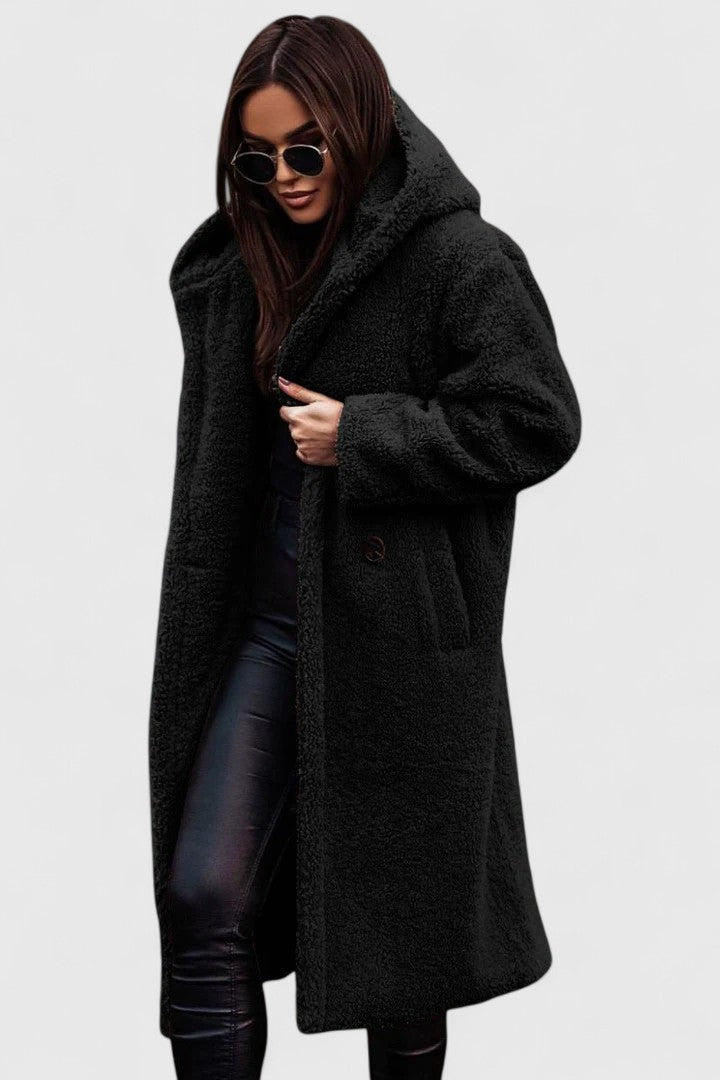A woman wearing a long, softly textured hooded winter coat with an open front