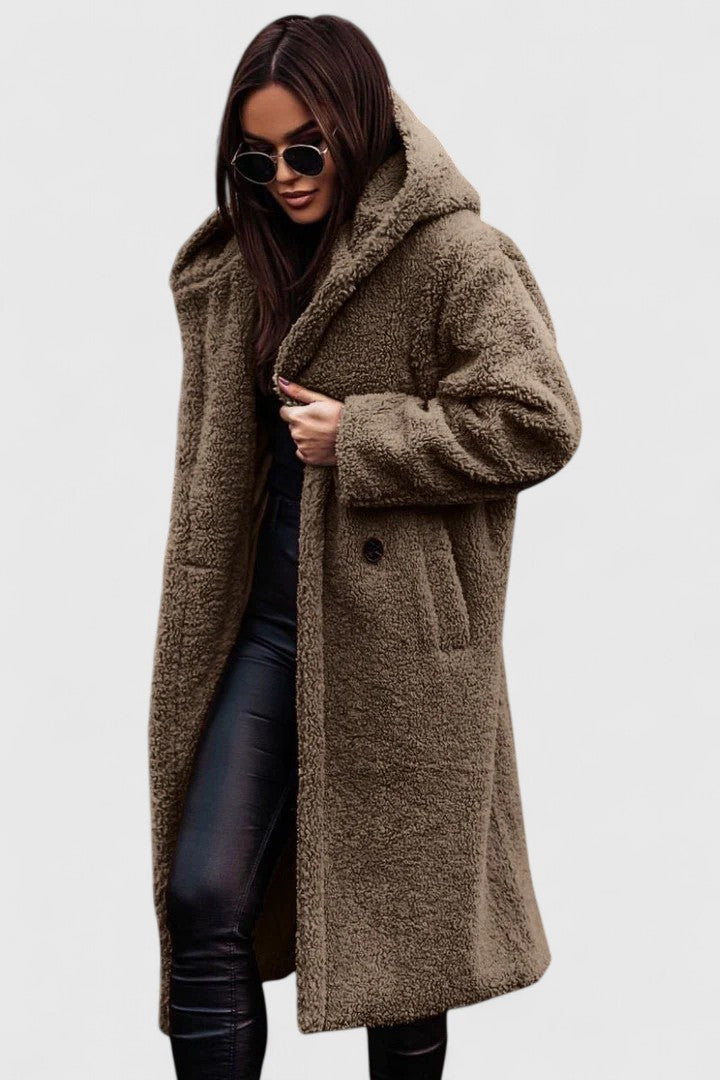 A woman wearing a long, softly textured hooded winter coat with an open front