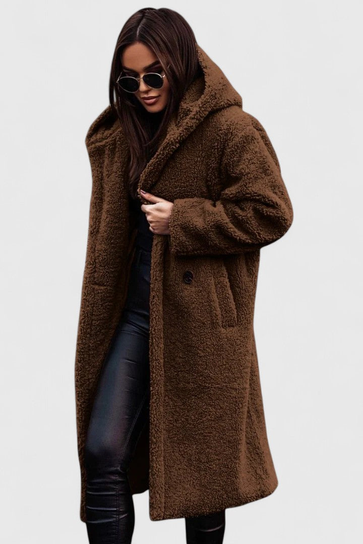 A woman wearing a long, softly textured hooded winter coat with an open front