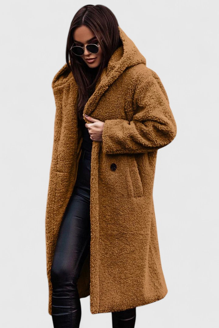 A woman wearing a long, softly textured hooded winter coat with an open front