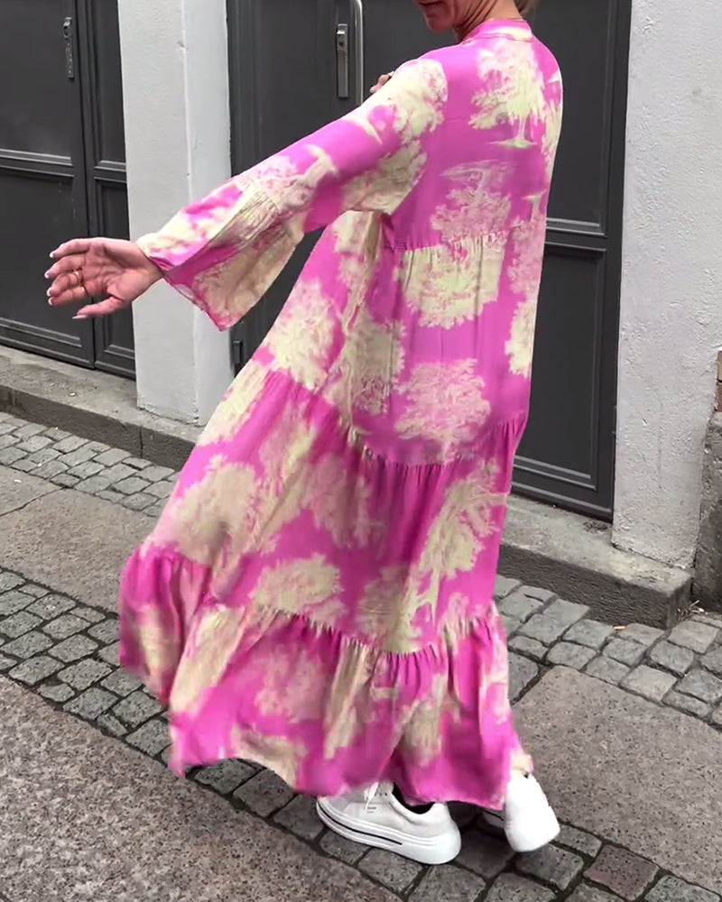 Woman wearing the Sylvie flowing maxi dress with a delicate print and V-neckline, the skirt moving softly as she walks.