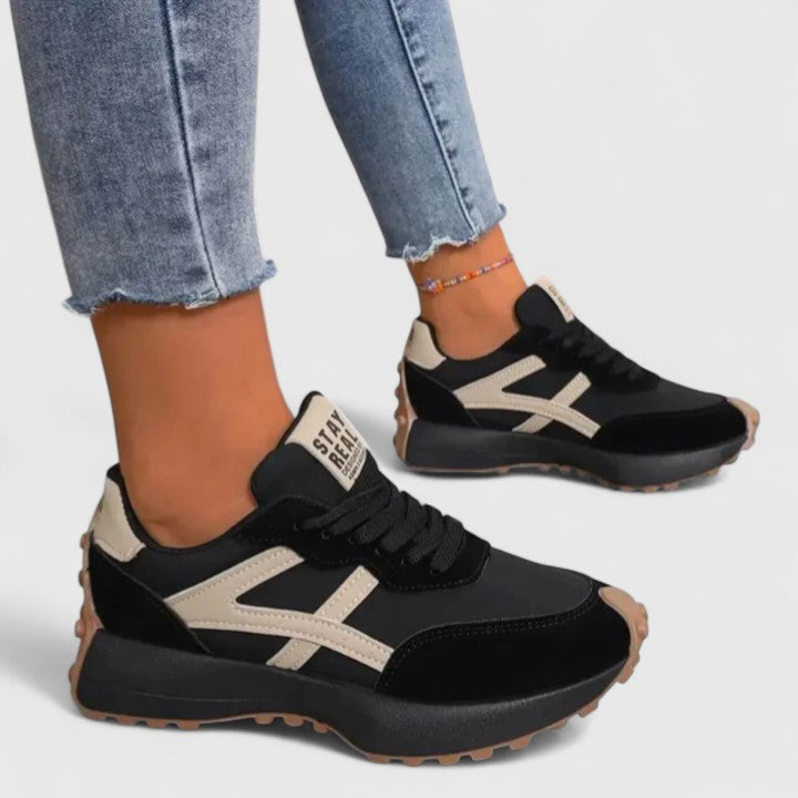 A woman wearing neutral contrast orthopaedic sneakers on a city walk.