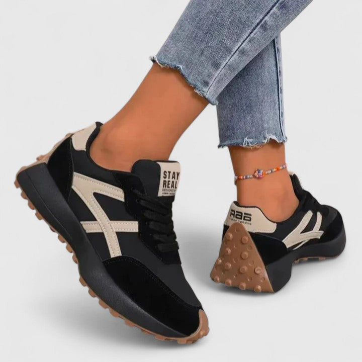 A woman wearing neutral contrast orthopaedic sneakers on a city walk.