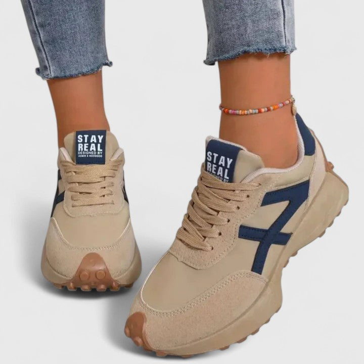 A woman wearing neutral contrast orthopaedic sneakers on a city walk.
