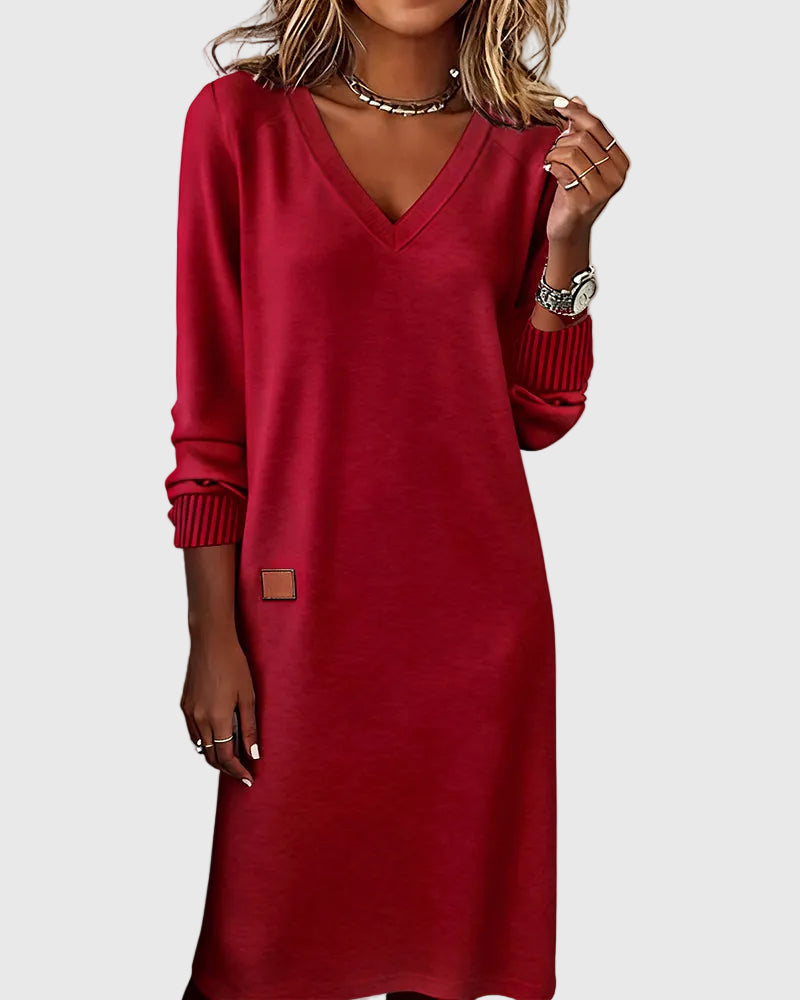Woman wearing the Susan flowing elegant dress in beige, standing relaxed and smiling.