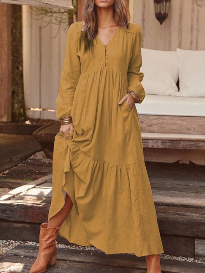Woman walking through the countryside in the Veronique tiered maxi dress with long sleeves and a flowing flounced hem.