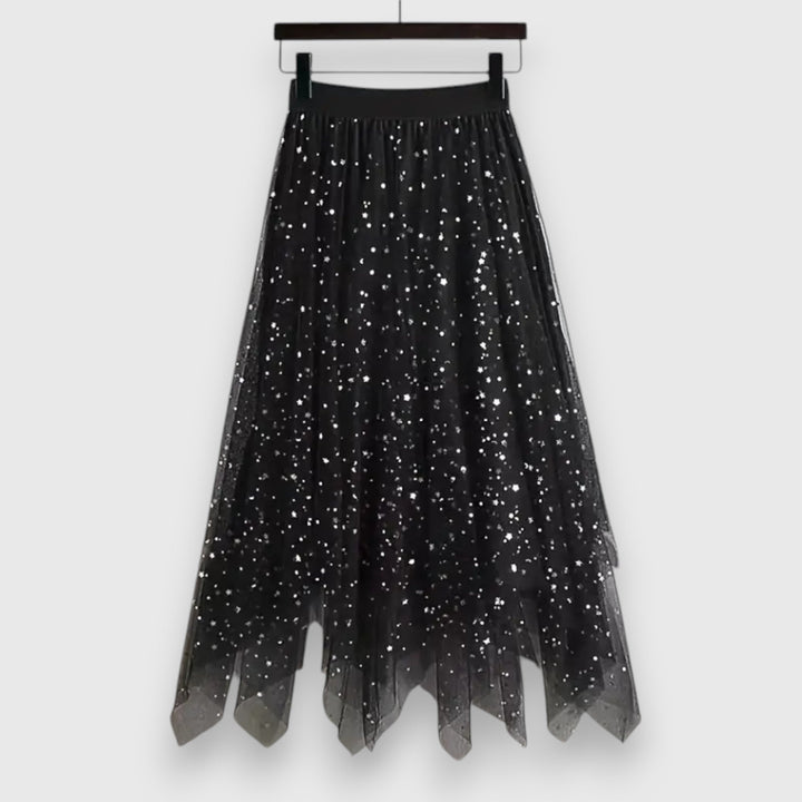 A woman wearing a high-waisted shimmering skirt with a soft ruffled hem.