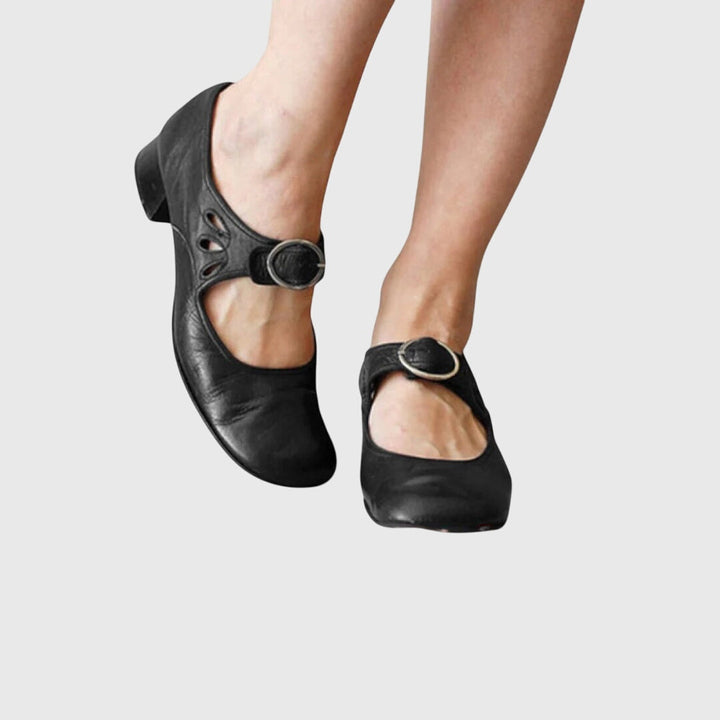 A woman wearing low heel Mary Janes with an adjustable strap, dressed for work.