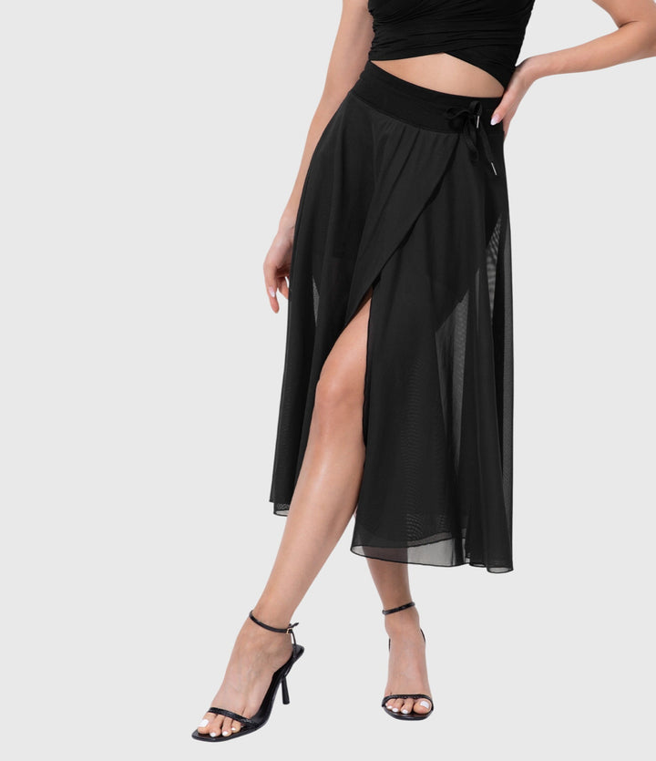 A woman in an elegant high-waisted flowing skirt, styled for a versatile day-to-evening look.
