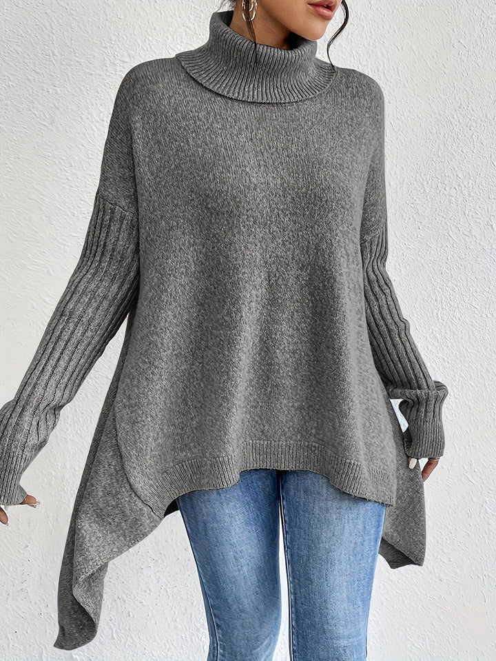A woman wearing a stand-collar sweater with a chic asymmetric drape, warm and polished.