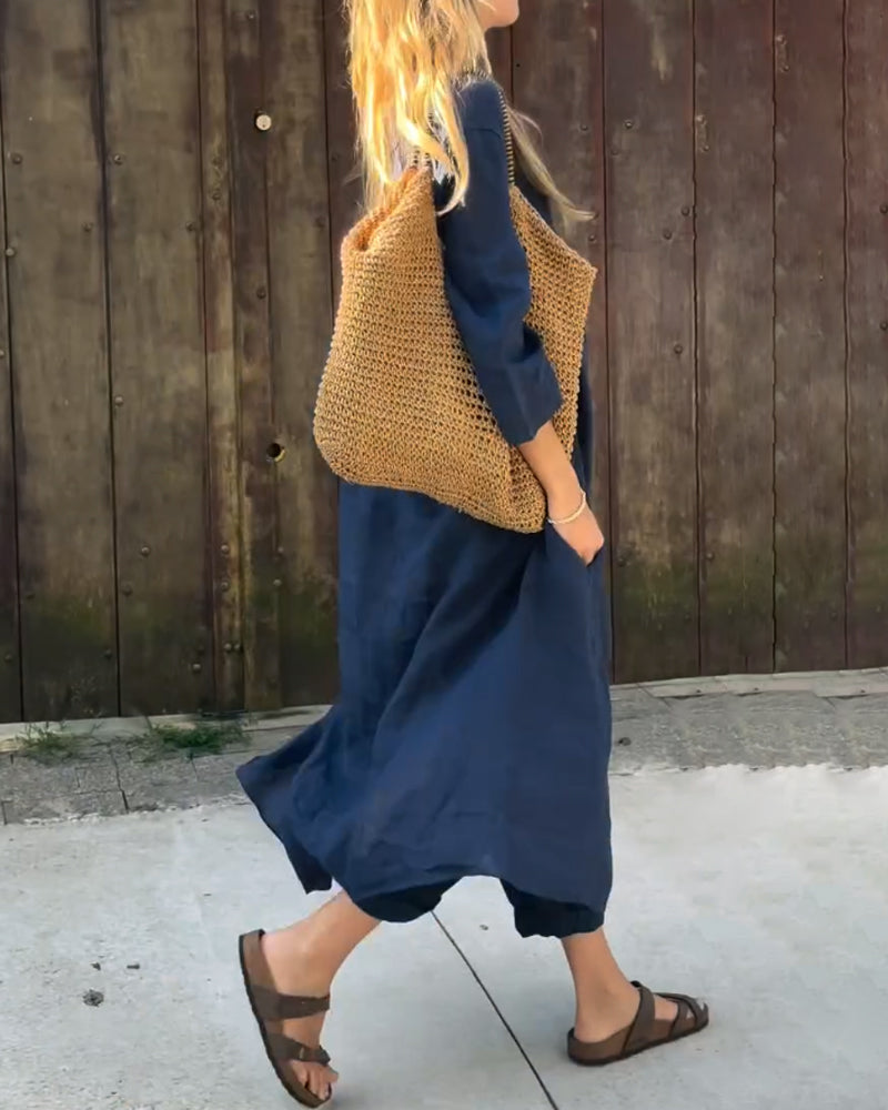 A woman wearing a blue asymmetric tunic with wide-leg pants