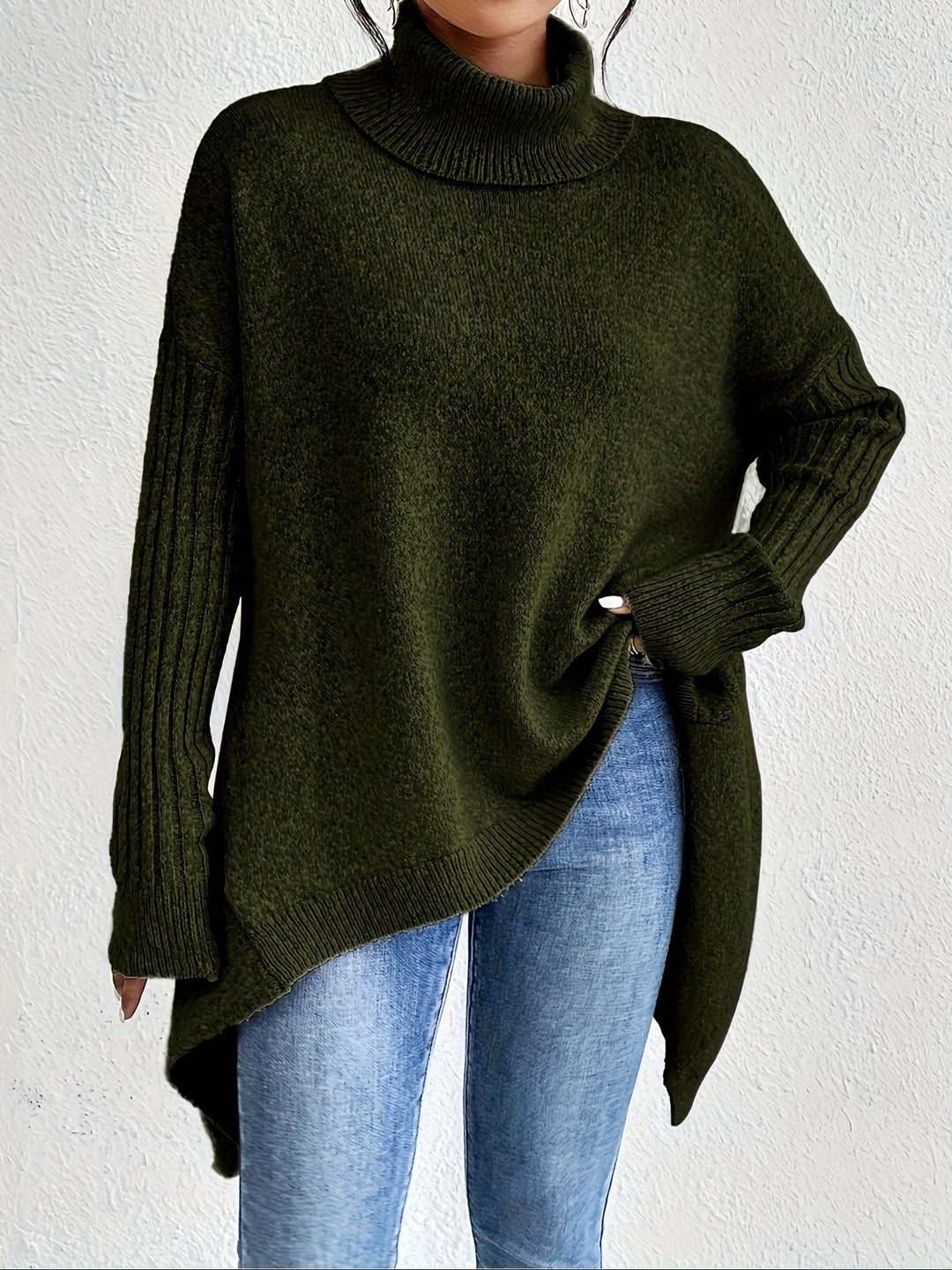 A woman wearing a stand-collar sweater with a chic asymmetric drape, warm and polished.